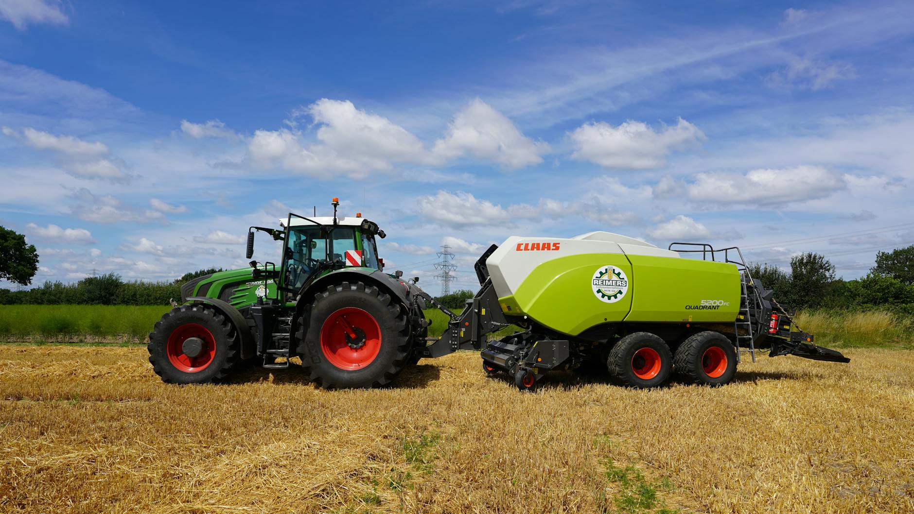 Ciągnik z prasą kostkującą pracujący na słonecznym polu pszenicy