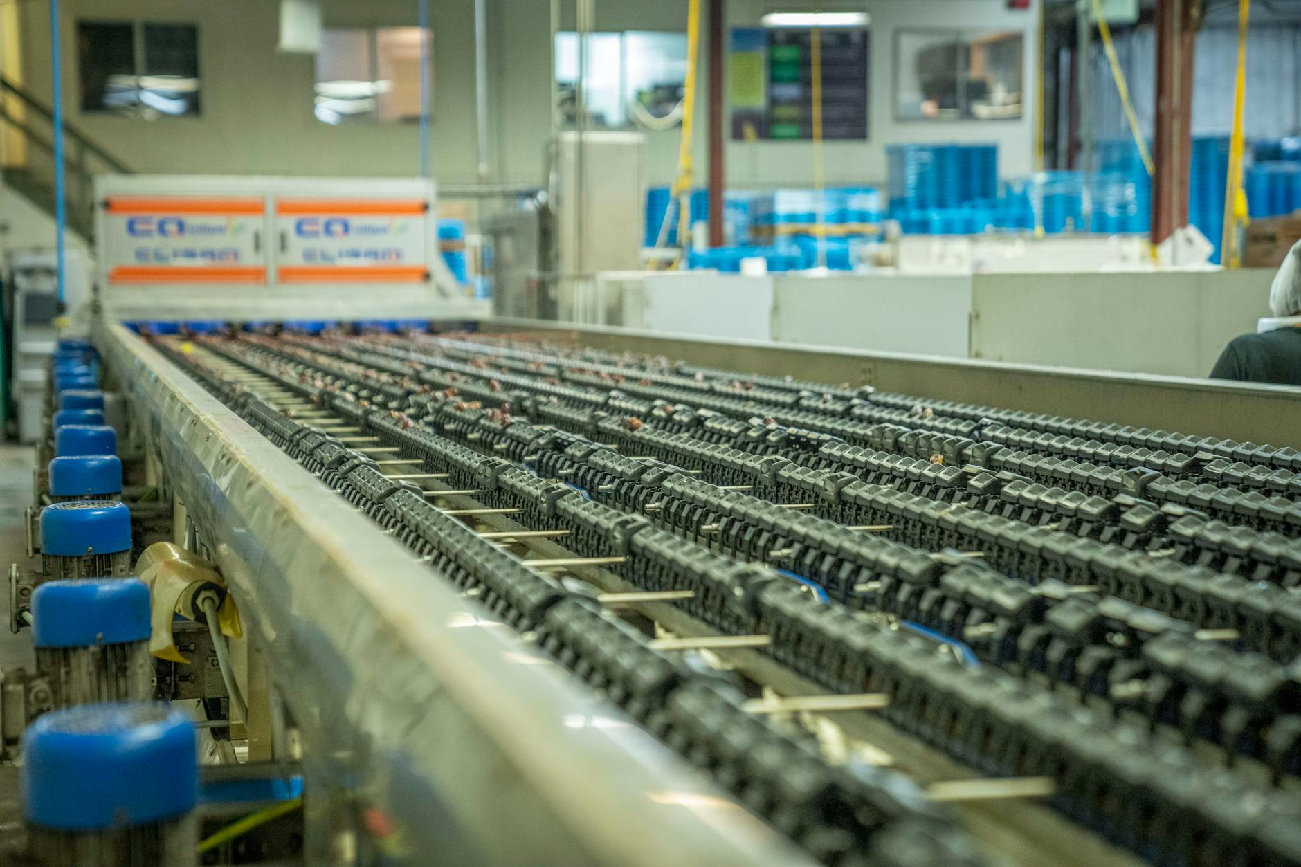 Podajnik pochyły: listwy, łańcuchy i prowadnice – co zmienia komfort pracy Zbliżenie na przemysłowy podajnik taśmowy w hali produkcyjnej