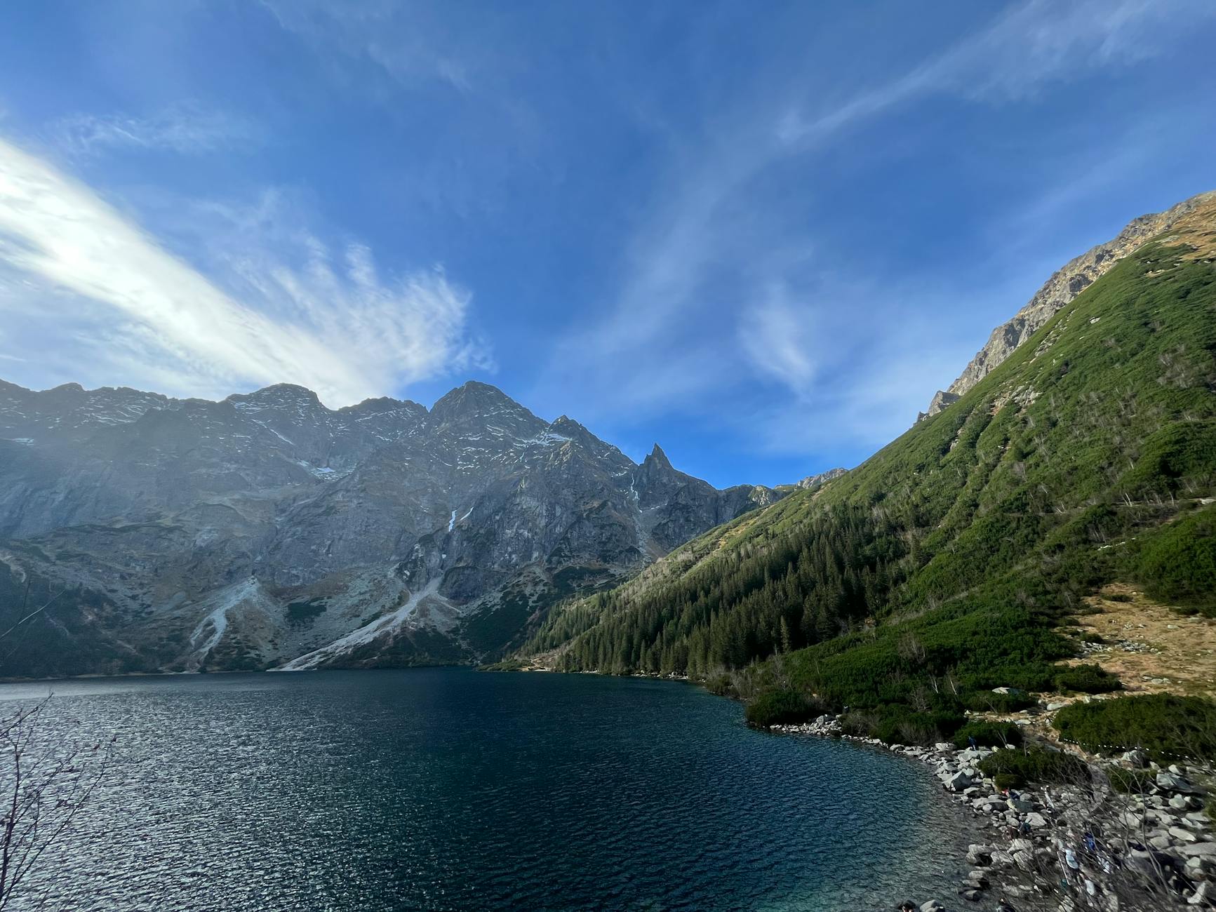 Morskie Oko otoczone skalistymi szczytami Tatr i gęstym lasem