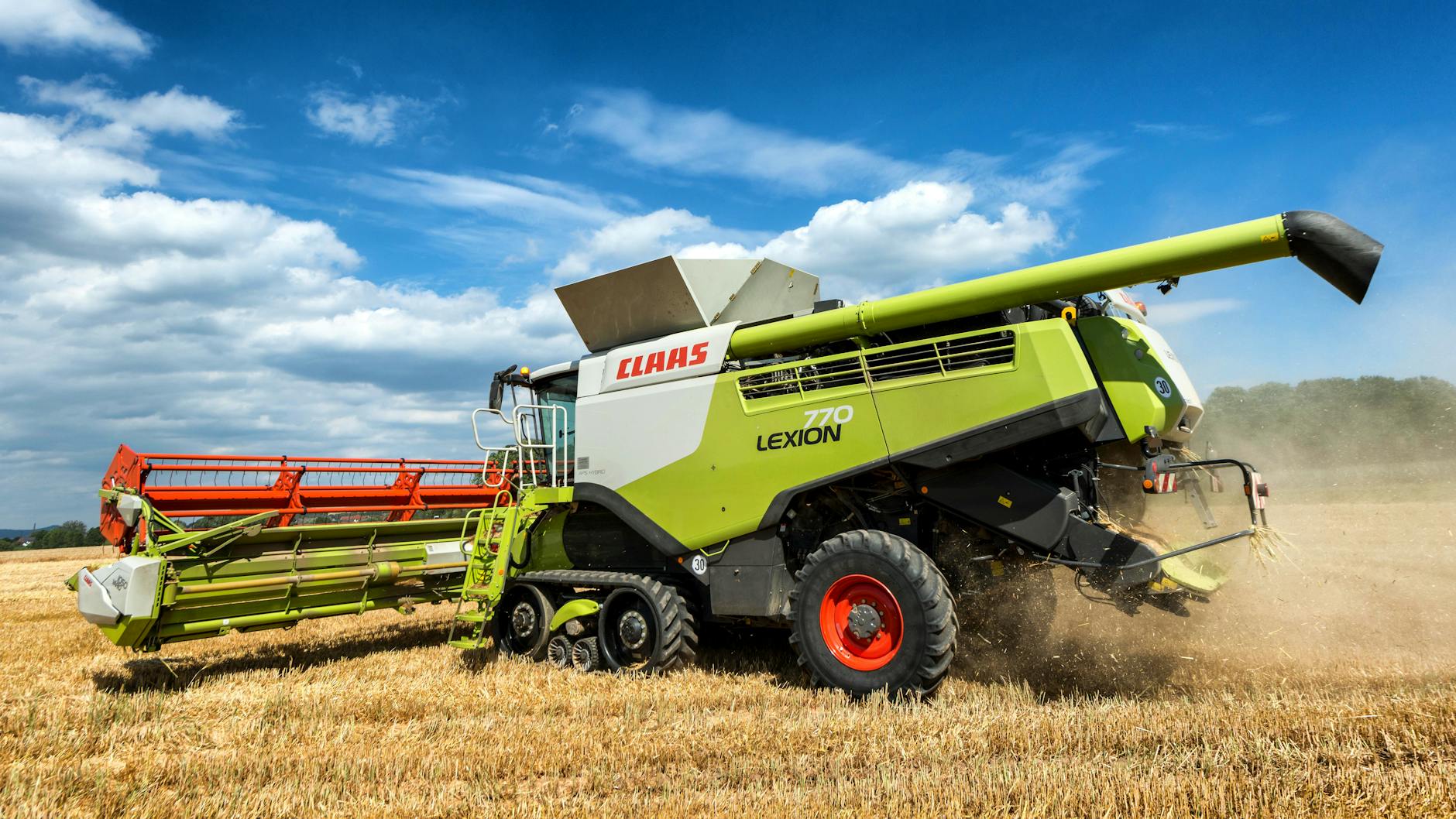 Zielony kombajn CLAAS LEXION podczas żniw na letnim polu w Niemczech