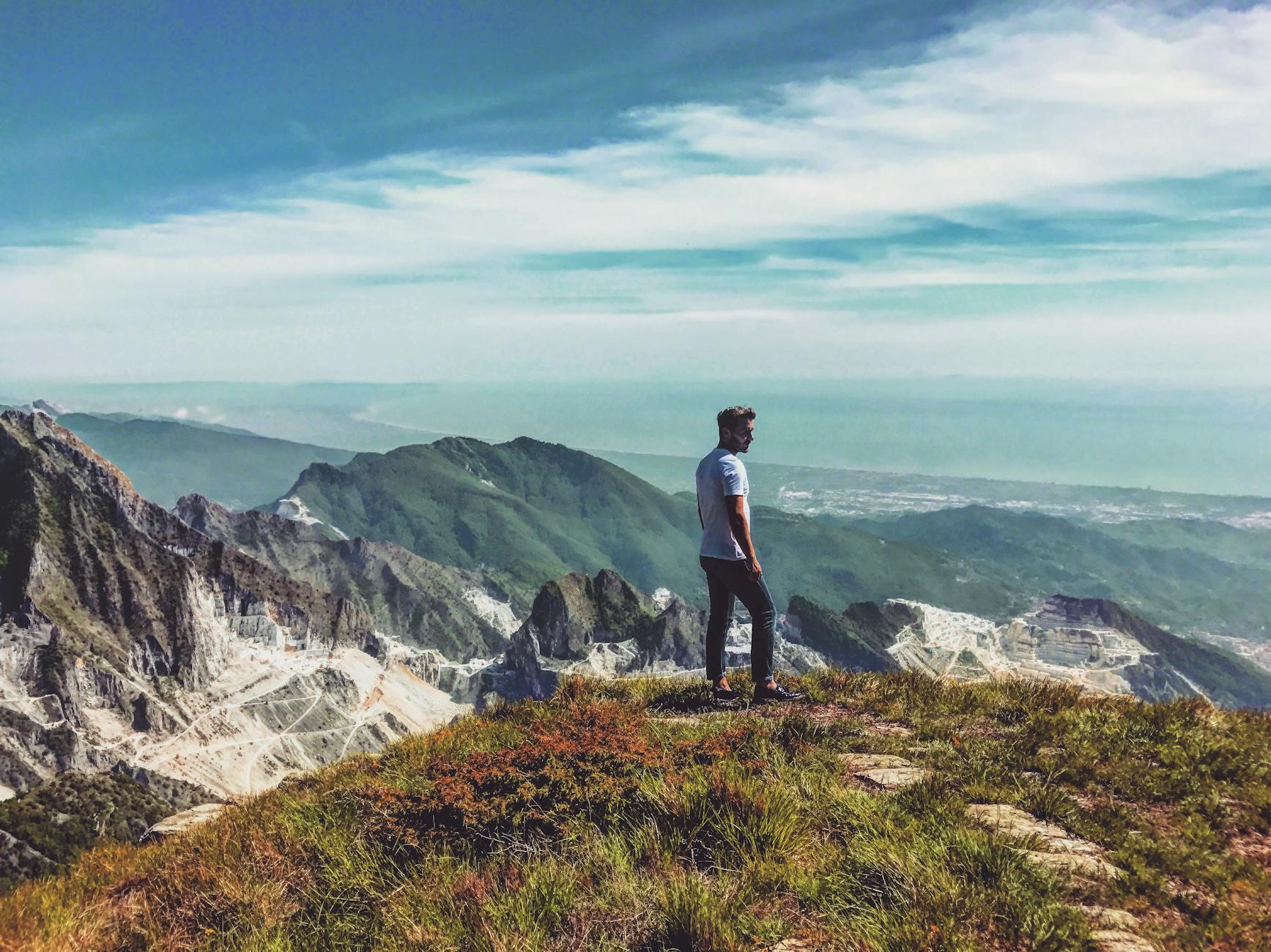 Turysta na wzgórzu podziwia górski krajobraz we włoskich Dolomitach