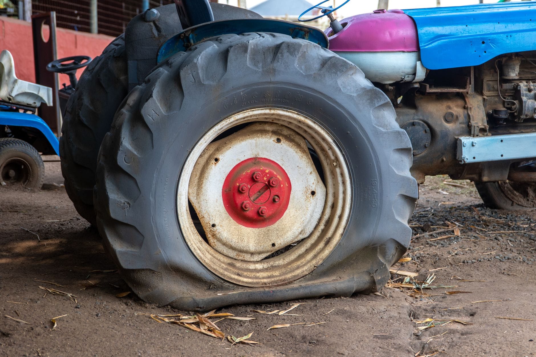 Stary traktor z przebitą oponą w rustykalnej stodole